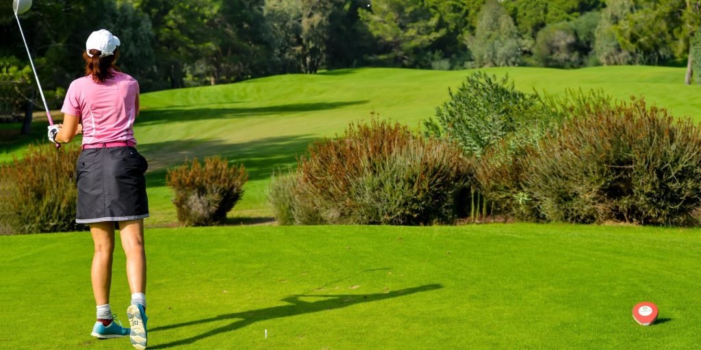 a woman golfer watching a far shot she hit